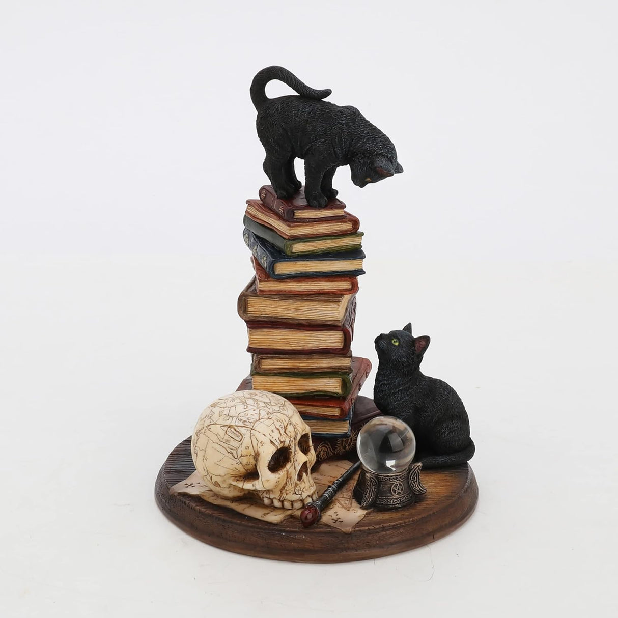 Figurine of cat on book stack with another black cat below by crystal ball, wand, skull, full color version