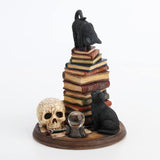 Figurine of cat on book stack with another black cat below by crystal ball, wand, skull, full color version