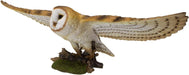 Flying barn owl figurine with brown and white feathers, shown from the side