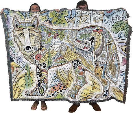 Two people holding a colorful blanket with animal designs.