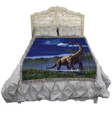 Dinosaur-themed blanket draped over a bed with a white headboard.