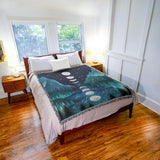 Bedroom with a bed featuring a decorative blanket with moon phases design.