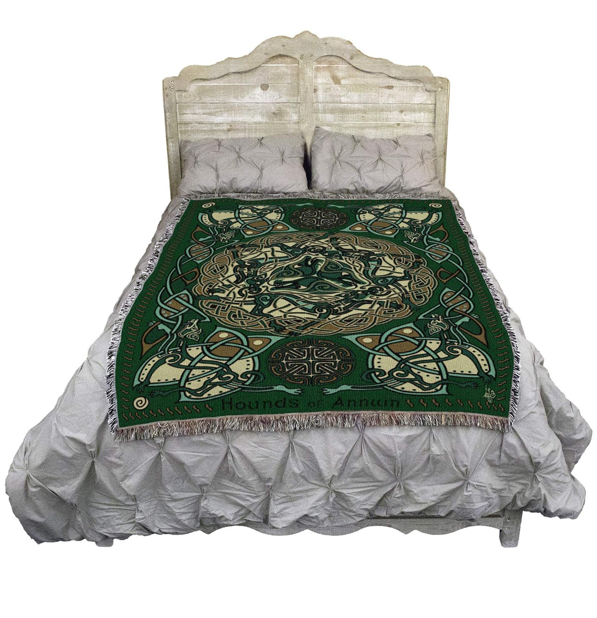 Tapestry blanket in green, gold and cream with Celtic hound knotwork design, shown on a bed