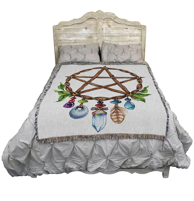 Pentacle charm tapestry blanket shown draped over a bed