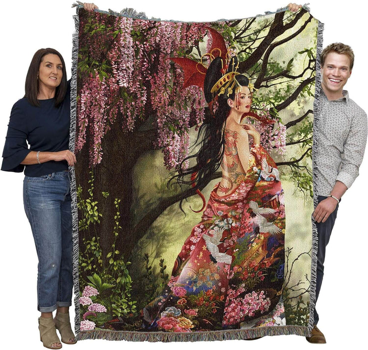 Tapestry blanket held by two adults, showing large size