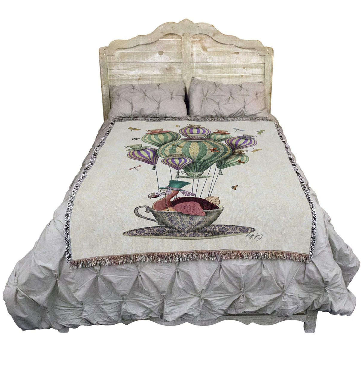 Woven blanket with a colorful design of a dodo in a teacup on hair balloon with dragonflies and butterflies, shown on a bed