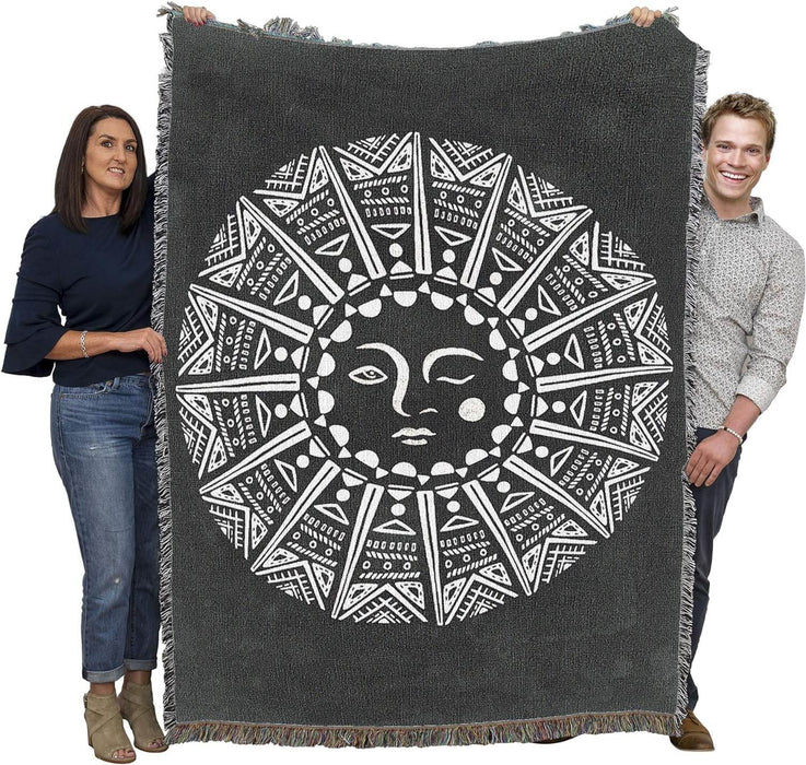 Two adults holding up tapestry blanket to show large size