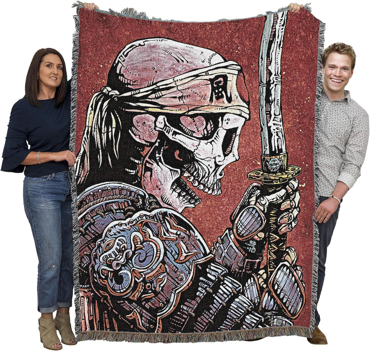 Two people holding a large blanket with a skeletal warrior design on a white background