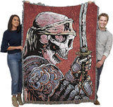 Two people holding a large blanket with a skeletal warrior design on a white background