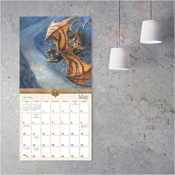 Wall calendar with dragon illustration for May on a textured wall