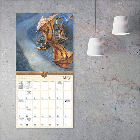 Wall calendar with dragon illustration for May on a textured wall
