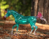 Model unicorn with clearware aqua body, white socks and tail tip, pink hooves, tail, mane, nose and horn, shown in the forest