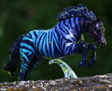Breyer jumping horse figurine with zebra pattern in gradient purple-blue on black