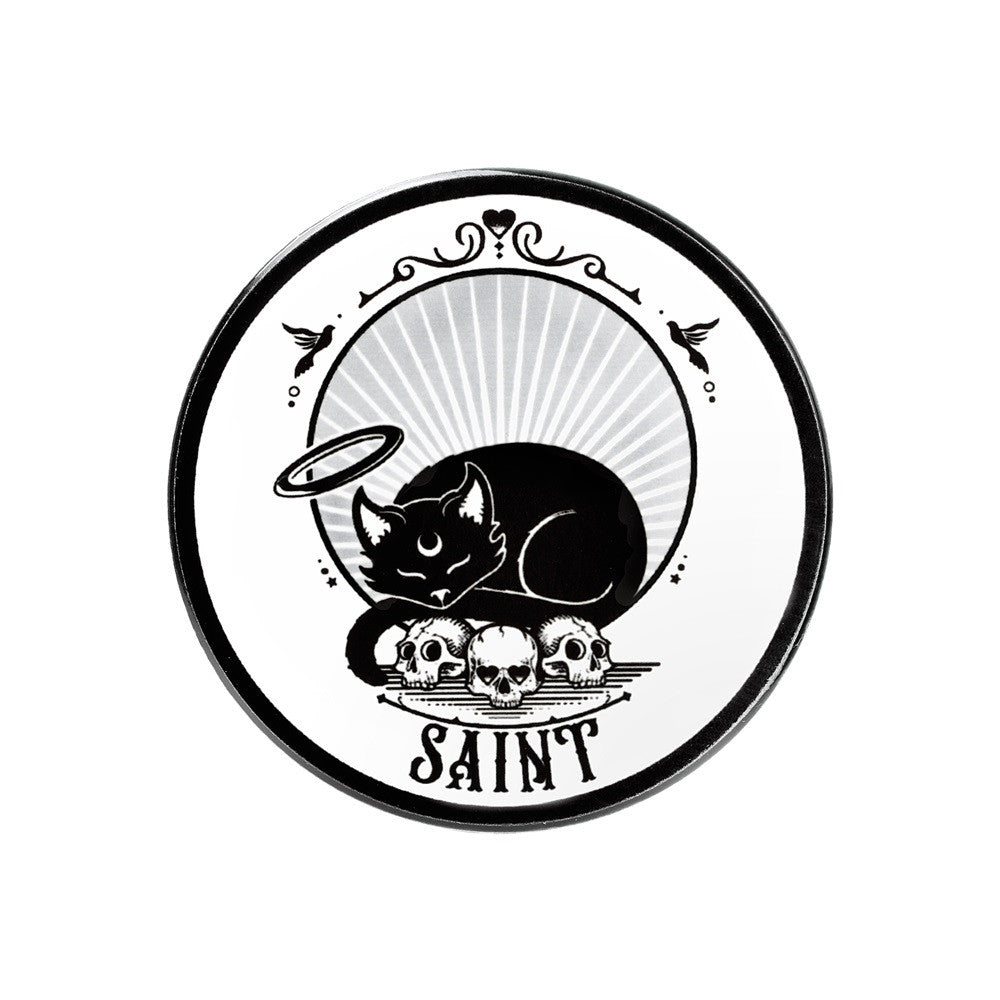 White coaster with black cat with halo sleeping on skulls above word "Saint"