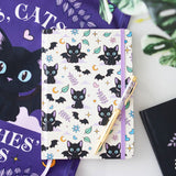 Notebook with black cat and bat pattern and pen