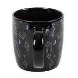 Mug with designs of crystals, witch hats, moons, stars, potion bottles, candles on black background