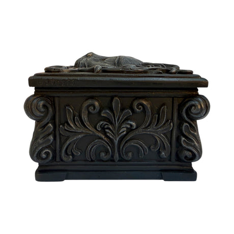 Black trinket box with cat face on lid, shown from the side with swirls