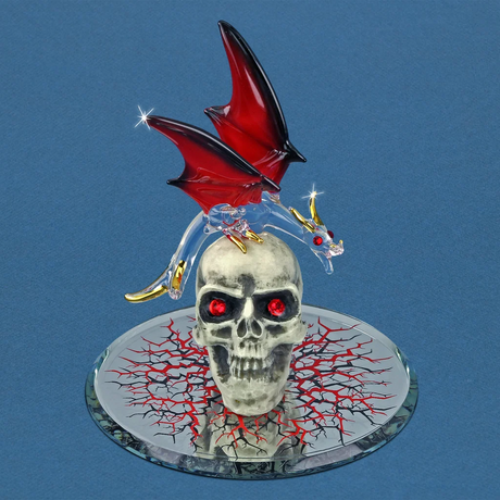 Glass figurine of dragon with red and black wings and gold accents on a white skull with red eyes, on a mirrored base