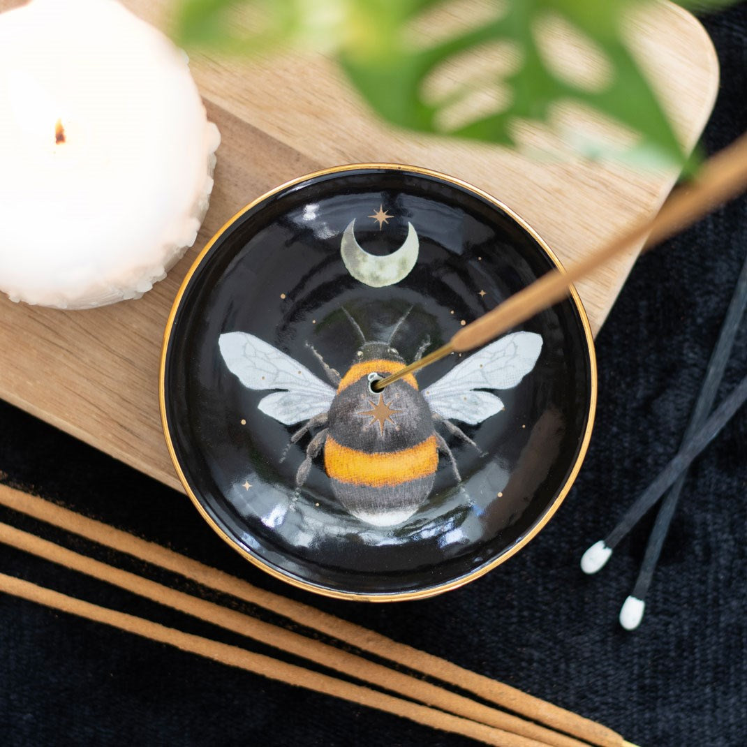 Incense burner dish, round, with bee and moon design, shown with incense