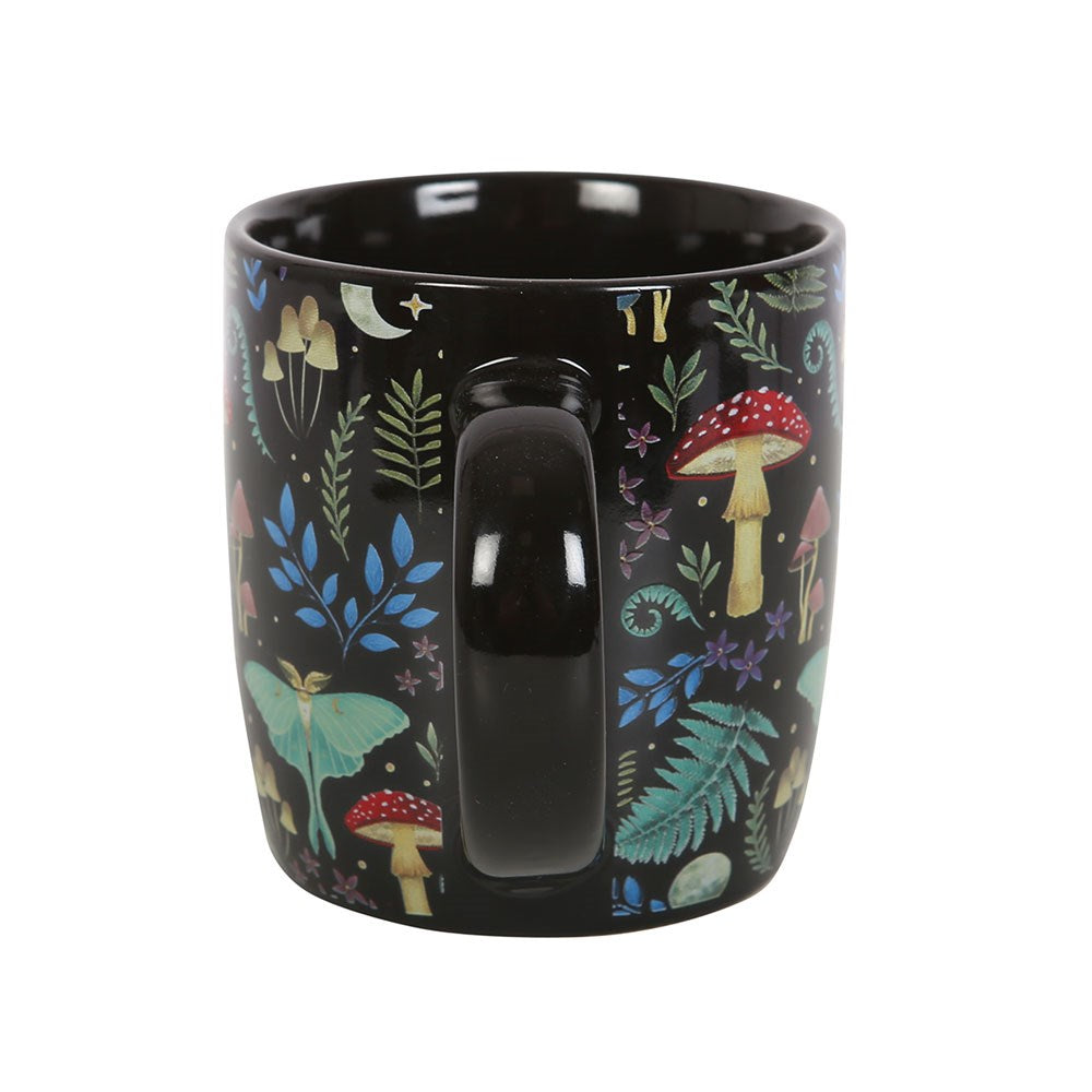 Black ceramic mug with designs of mushrooms, ferns, luna moths