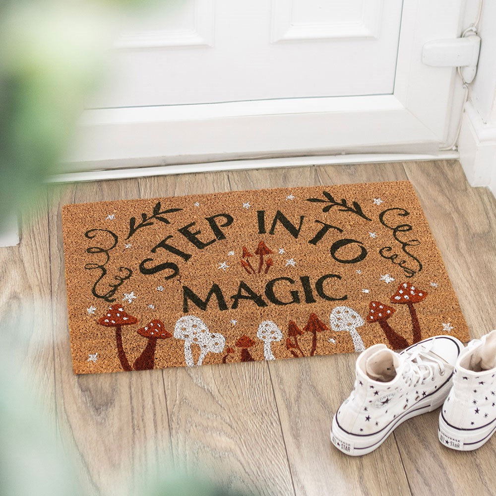 Doormat with 'Step into Magic' text on a wooden floor with white sneakers.