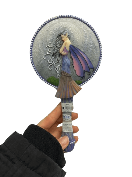 Hand mirror featuring a fairy with pink and purple wings on the back