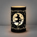 Lantern light of black etched glass with witch riding broomstick in front of a full moon. Bats and stars and witchy accents