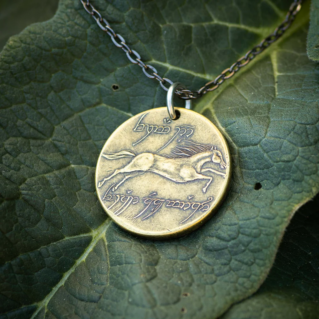 Brass Lord of the Rings pendant with horse design and Elvish runes on a green leaf