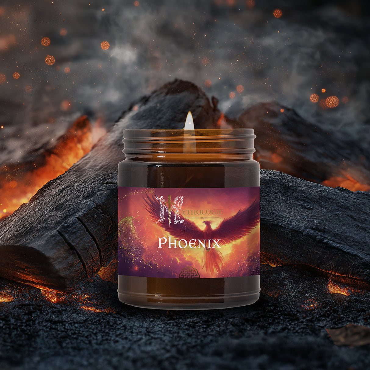Candle in a jar labeled 'Phoenix' with a fiery design, surrounded by glowing embers and logs.
