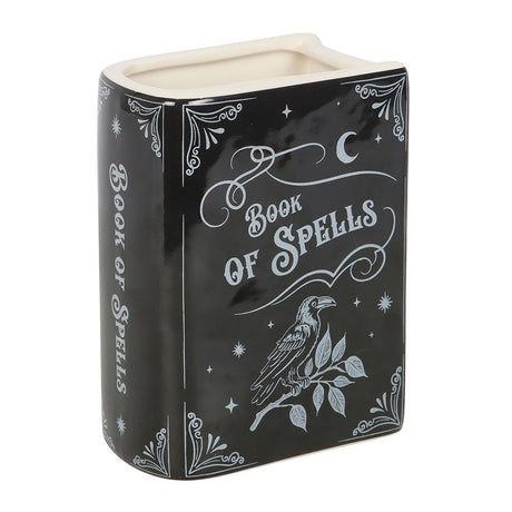 Black vase container with 'Book of Spells' design featuring a raven on a white background