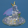 Glass figurine of dragon with purple wings and gold accents sniffing purple rose on mirror base