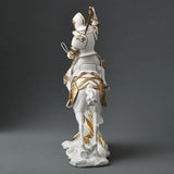 Statue of a knight on horseback with armor and sword, white and gold color scheme. View from the back
