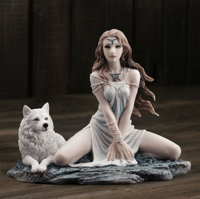 Figurine of brown haired elf in pale dress sitting with a white wolf