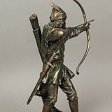 A bronze-hued figurine of Robin Hood drawing his bow with an arrow knocked