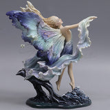 Back side view of the figurine showing colors in the wings and billowing garb