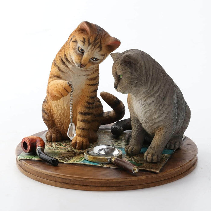 Orange tabby and grey cat contemplate a crystal while sitting on a map with magnifying glass & pipe nearby. Figurine based on artwork of Lisa Parker