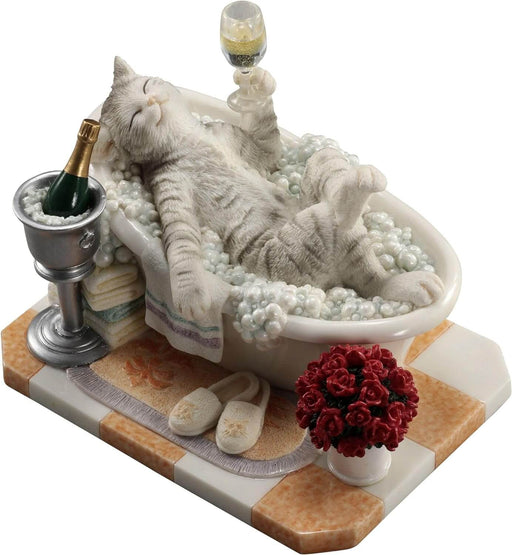 Figurine of a gray striped cat in a bubble bath with champagne, roses, and slippers.