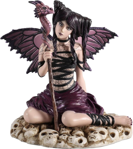 Fairy figurine of pixie with purple and black wings and outfit holding a dragon staff and sitting on skulls