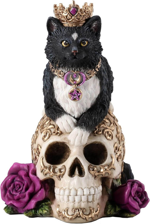 Figurine with a black and white cat in a crown and necklace of gold, sitting on a golden-swirled skull with purple roses