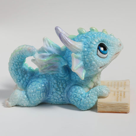 Blue dragon figurine with an open book