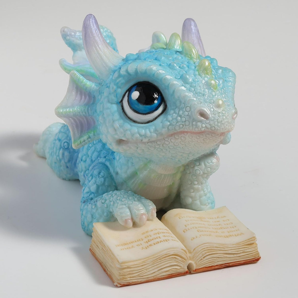 Blue dragon figurine with an open book