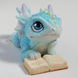 Blue dragon figurine with an open book