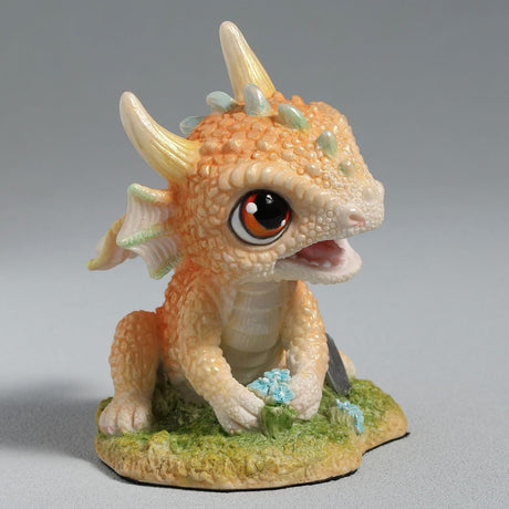 Figurine of a pale gold baby dragon gardening with flowers and a trowel