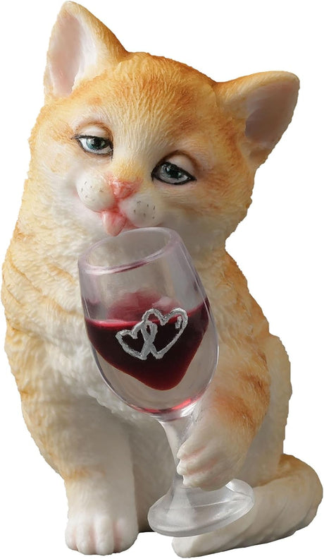 Orange cat figurine holding a wine glass with red wine