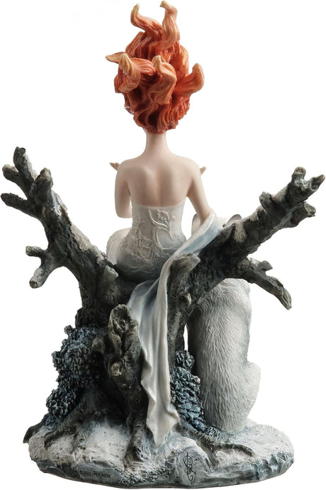 Statue of woman in white dress with red hair sitting on tree in winter landscape with a wolf, shown from the back