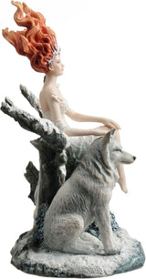 Statue of woman in white dress with red hair sitting on tree in winter landscape with a wolf, shown from the side