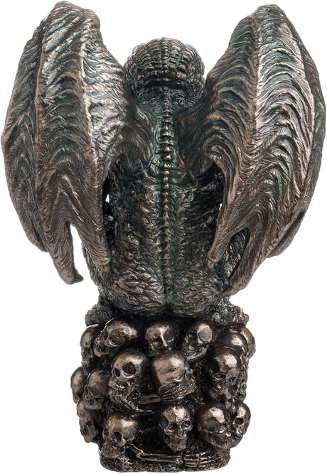 Statue of Cthulhu, winged with tentacles, crouched on a mound of skulls, shown from the back