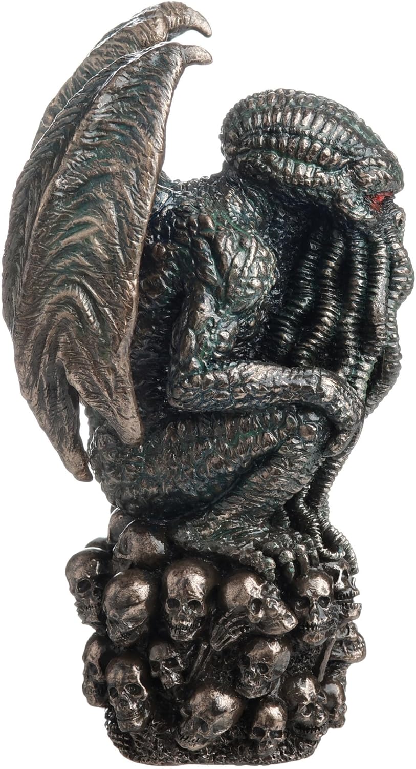 Statue of Cthulhu, winged with tentacles, crouched on a mound of skulls, shown from the side