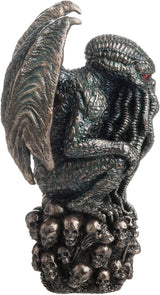 Statue of Cthulhu, winged with tentacles, crouched on a mound of skulls, shown from the side