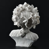 White bust of a woman with flowers for hair, shown from the back